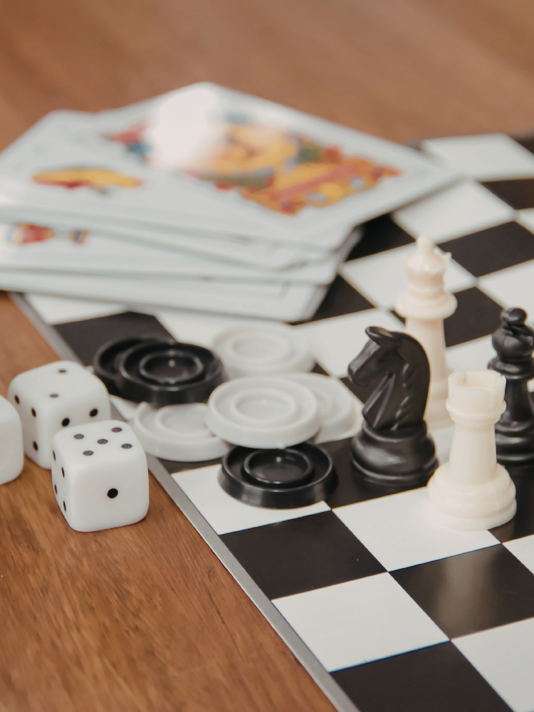 Dice, cards and game pieces on a checkered board