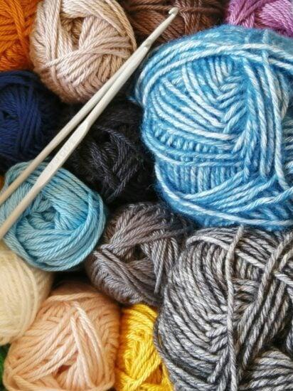 Colorful skeins of yarn and two crochet hooks