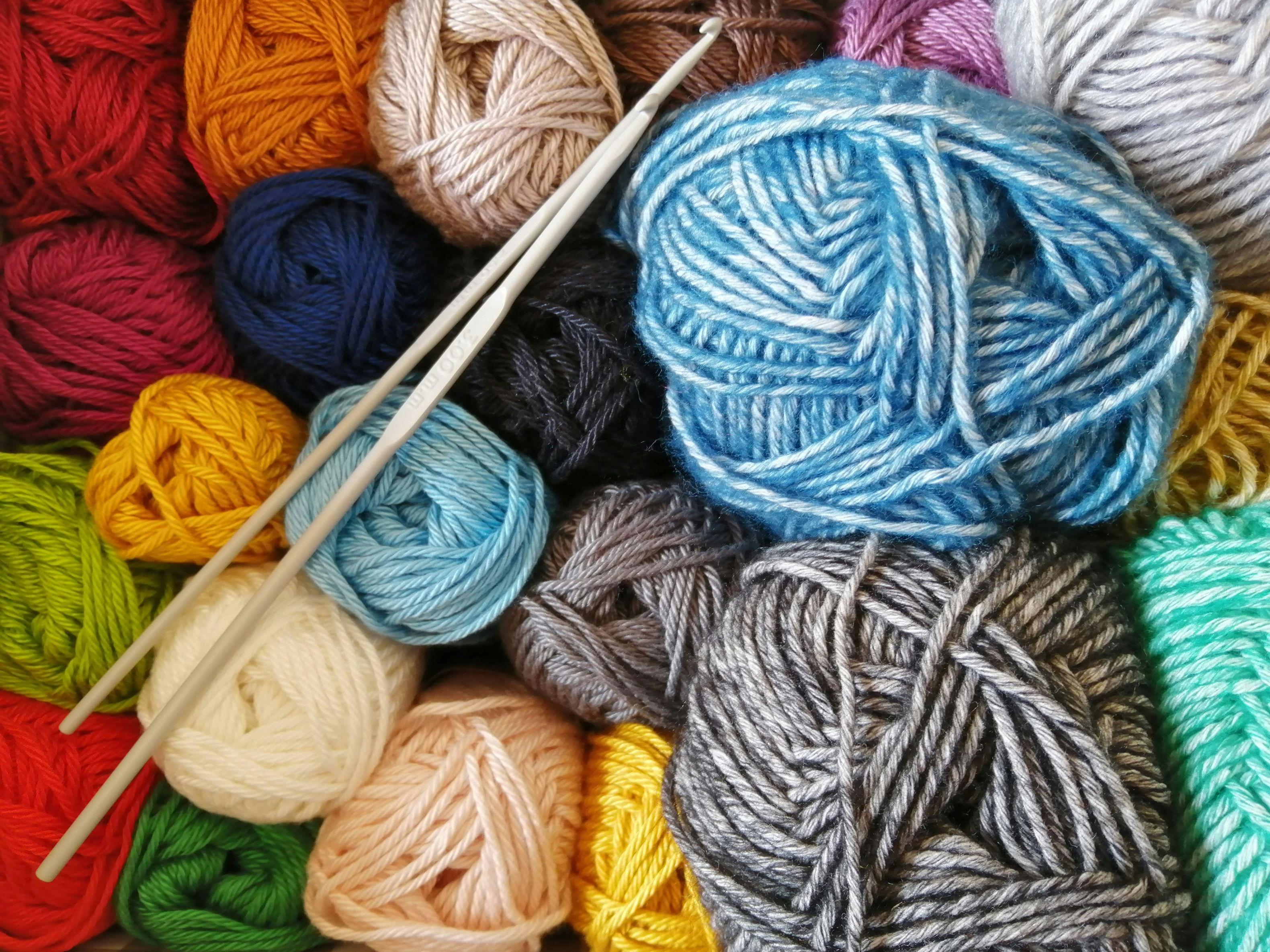 Colorful skeins of yarn and two crochet hooks
